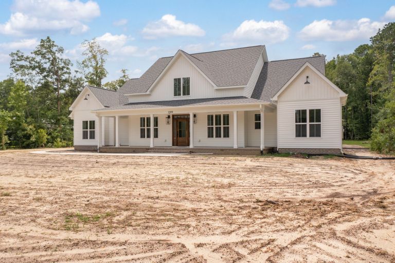 The Dawson Build: Modern custom farmhouse with white board and batten siding on Scott Road in Deep Run, NC by Signature Homes.