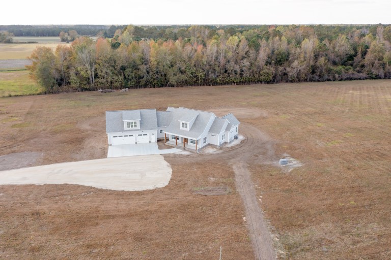Aerial view of The January Build: a sprawling, large-scale custom home with multiple garage bays on a spacious lot in Eastern NC by Signature Homes.